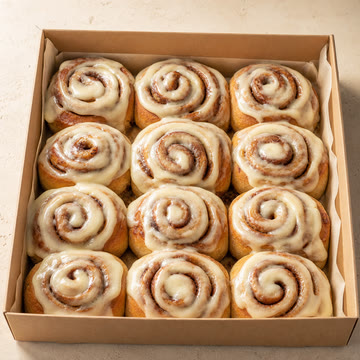 Caja abierta con 12 rolls de canela glaseados.